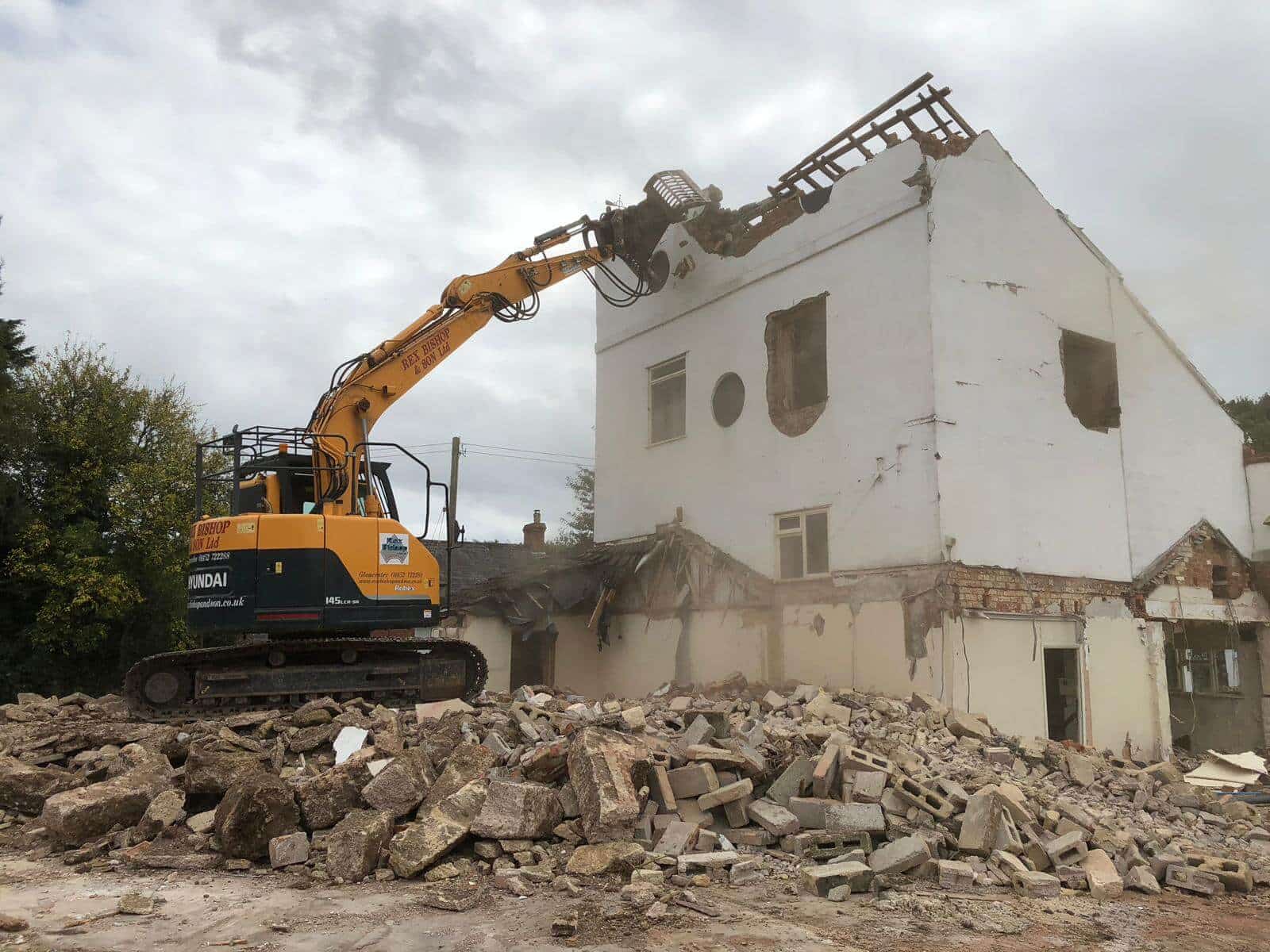 Digger ripping of the roof of an abandoned building