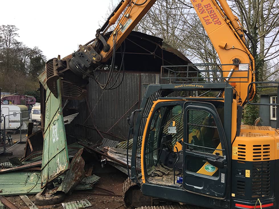 Digger demolishing an abandoned barn