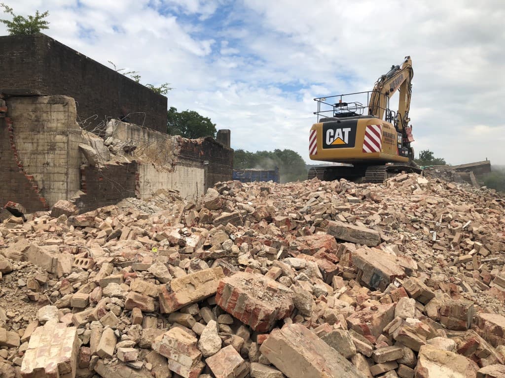 A CAT digger on a pile of rubble