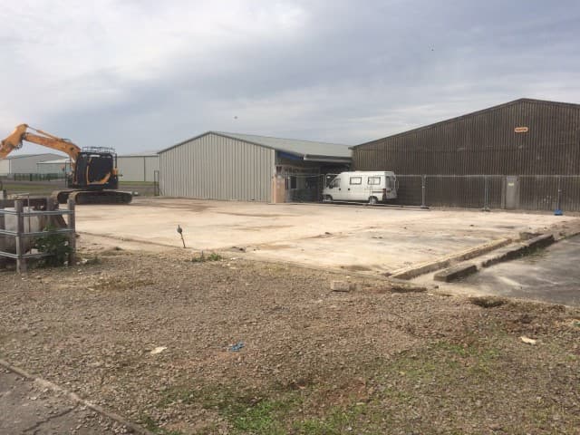 Empty ground in front of two hangars