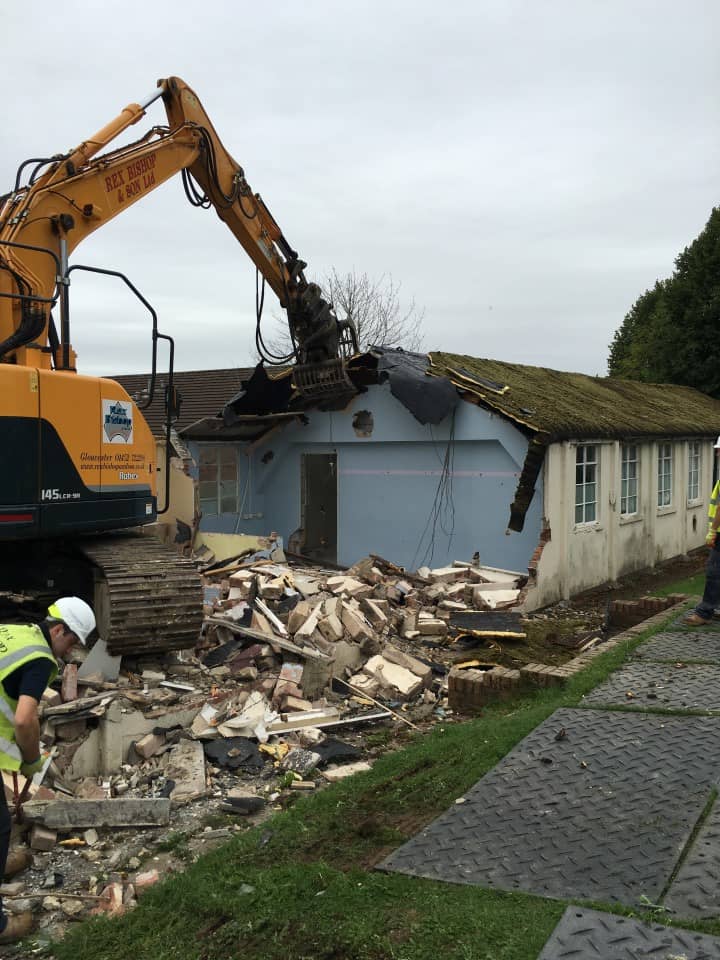 Digger ripping off a roof