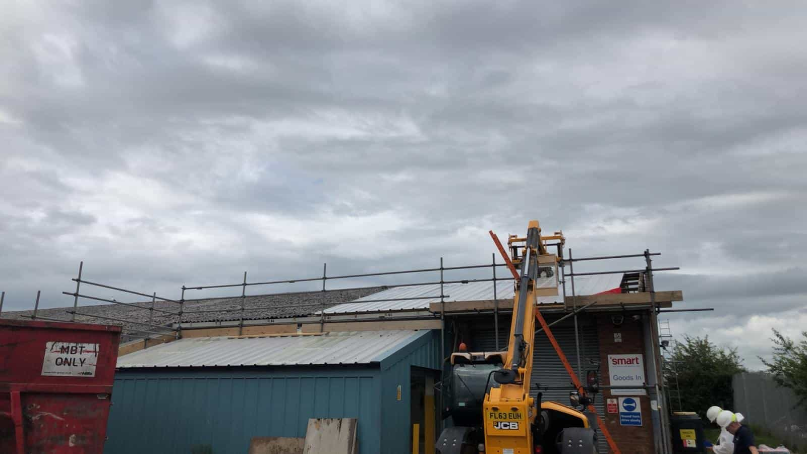 Roof of a building with scaffolding and a machine next to it