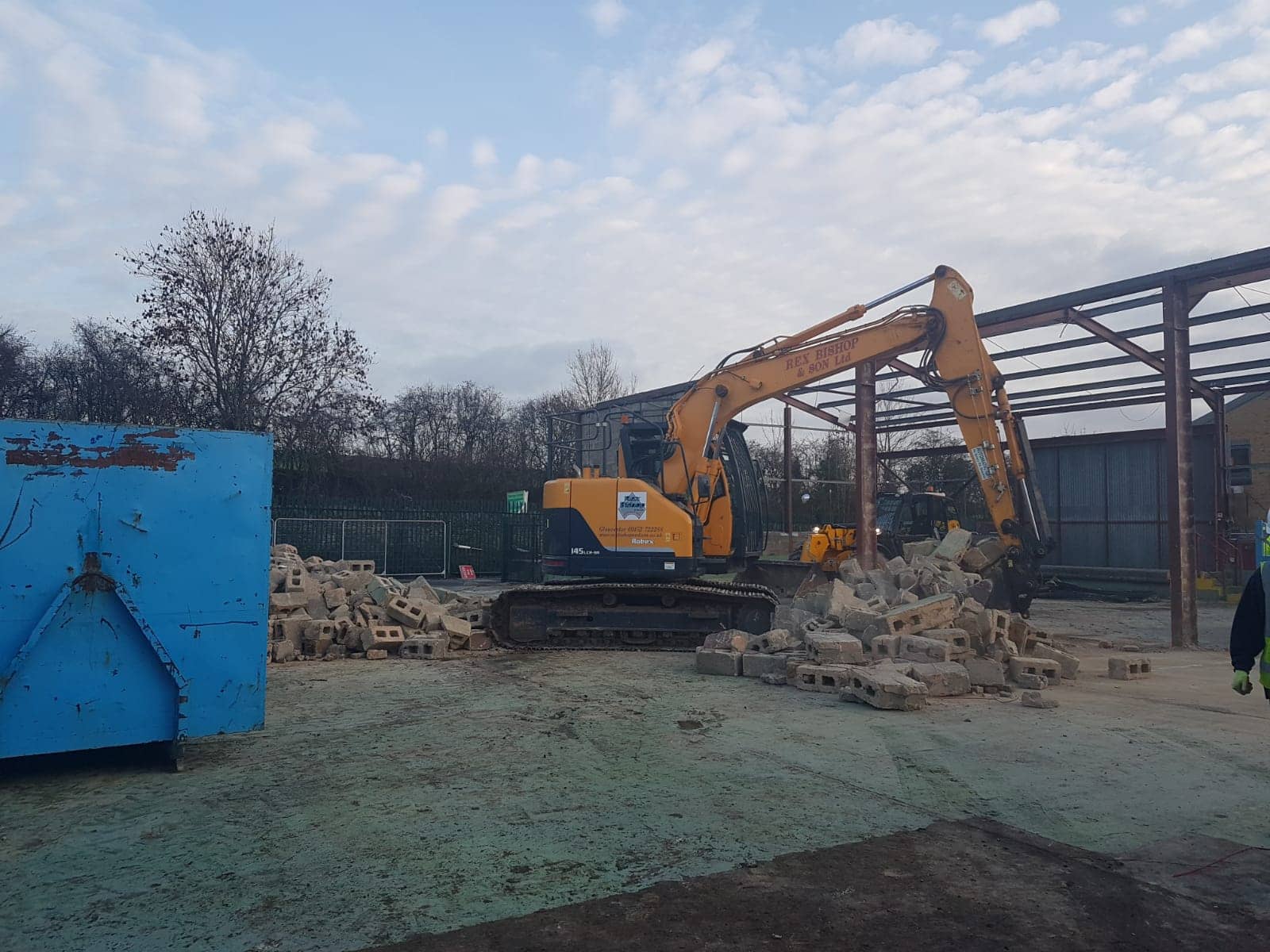 Digger on the outside of an empty building
