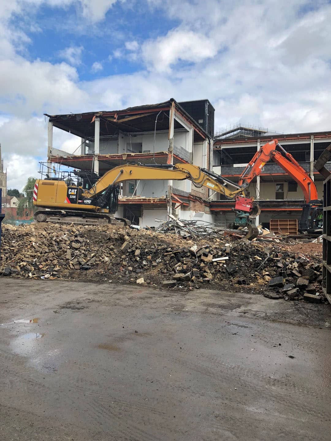 Two diggers behind a pile of rubble