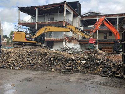 Digger outside of a building being demolished