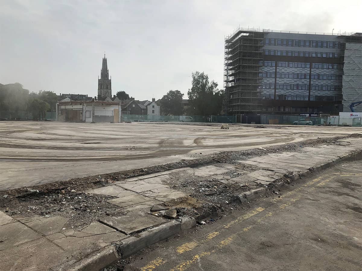 Empty concrete ground outside with buildings in the background