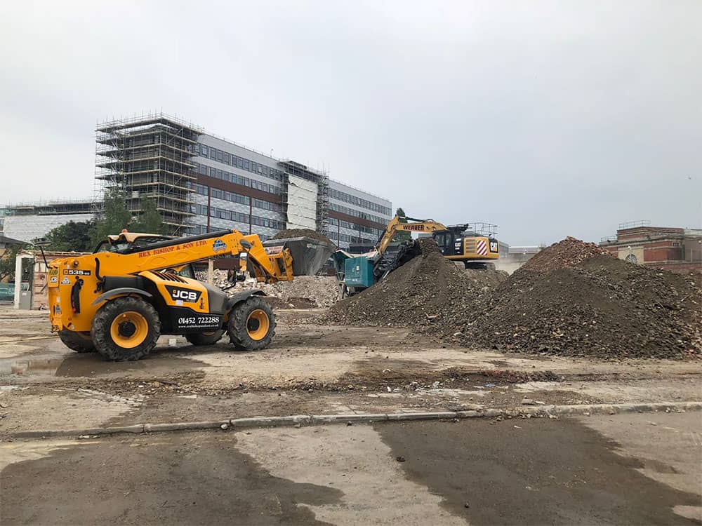 Two diggers behind a pile of rubble